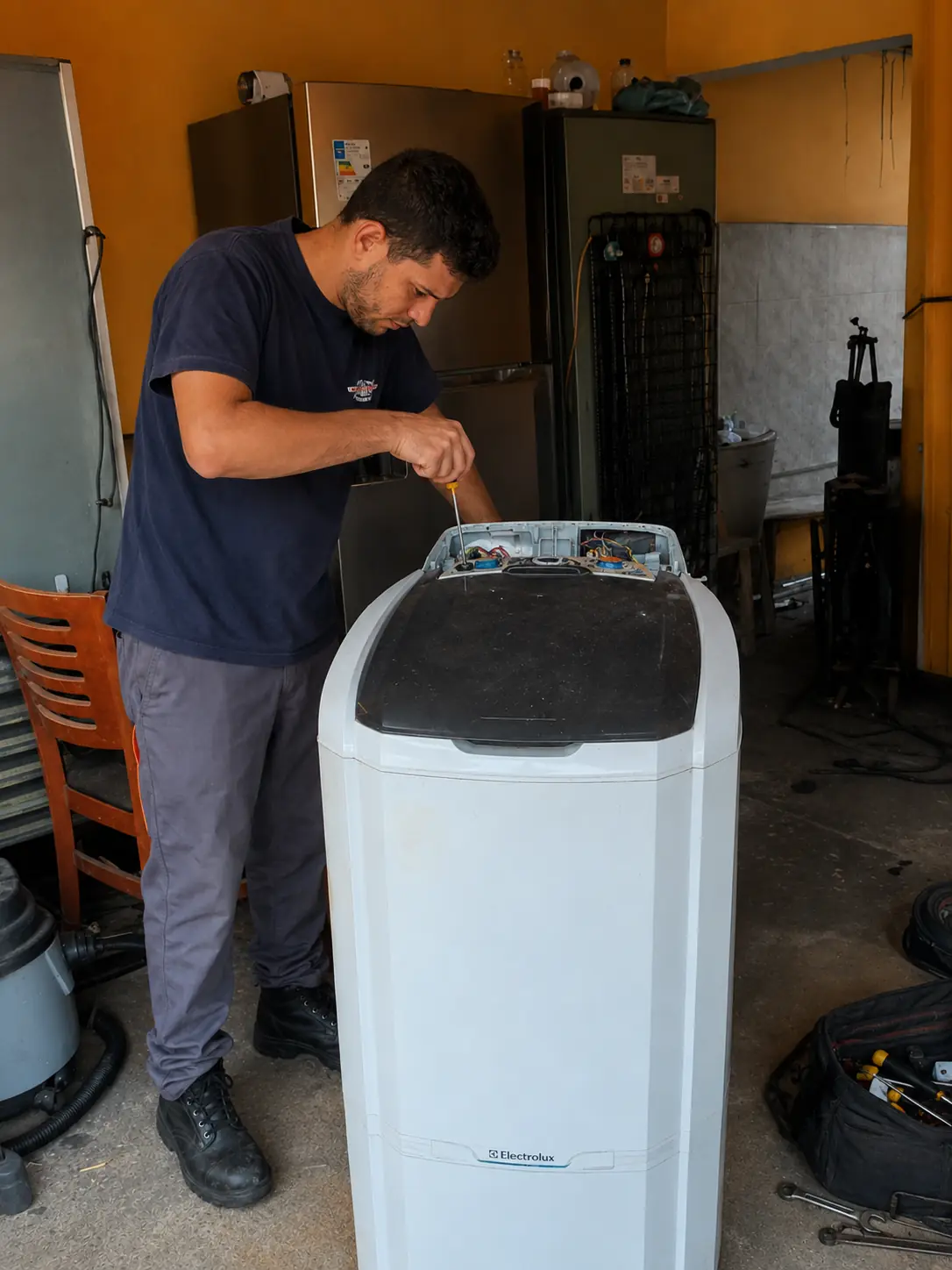 Técnico realizando manutenção em máquina de lavar
